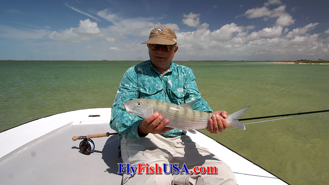 Mark Bachmann displays a fly caught Andros Island bonefish with a huge expanse of flats in the background.