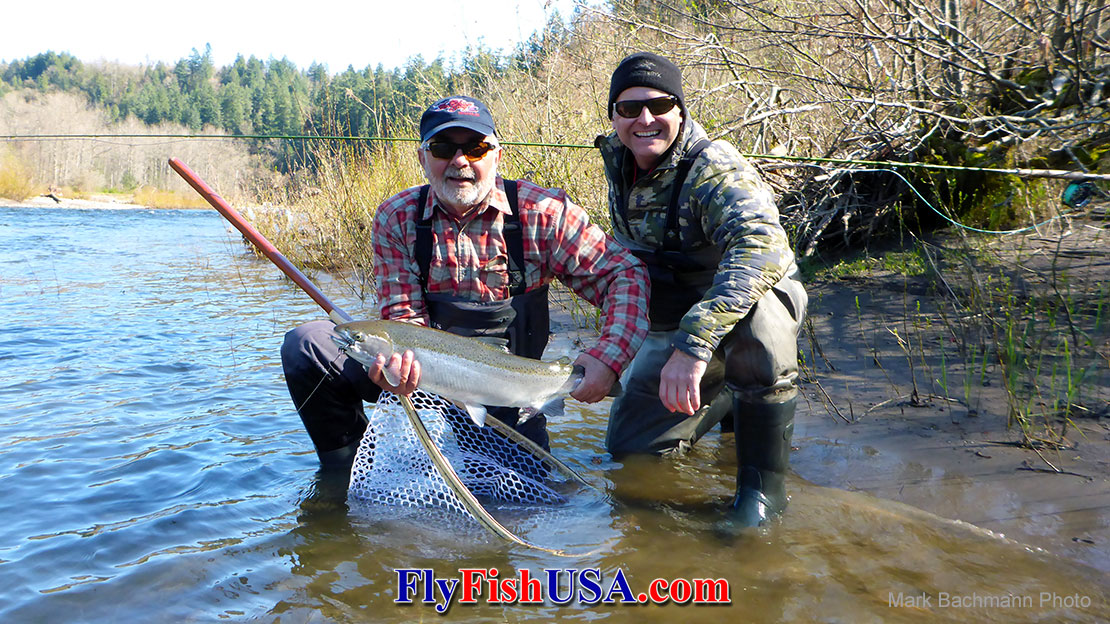 An Oregon angler and his guide display this Sandy River Winter Steelhead caught with a Black and Blue Wombat fly.